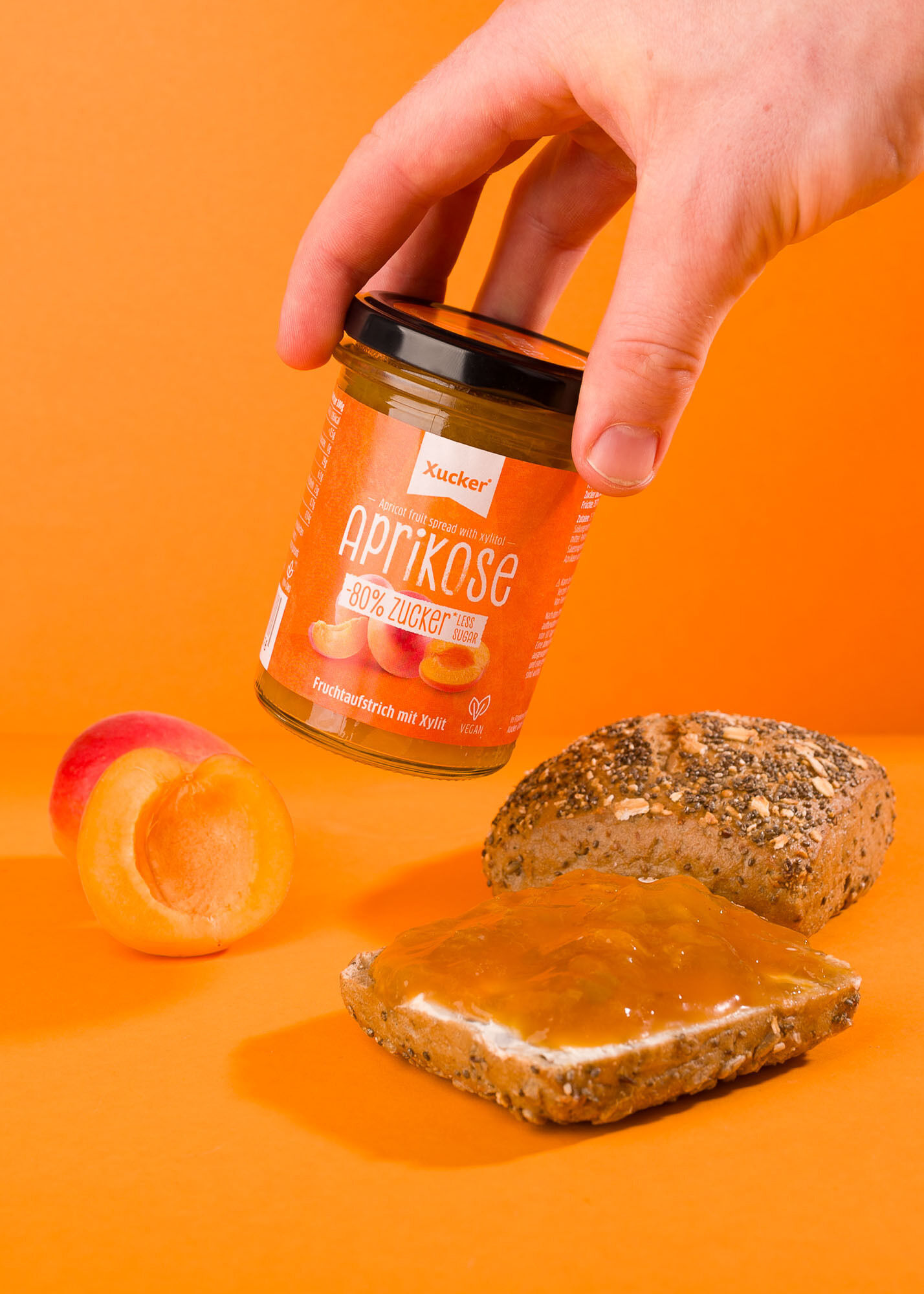 Xucker Aprikosenaufstrich – Fruchtig und lecker, mit weniger Zucker fuer vielseitigen Genuss auf Brot, Toast oder im Dessert - Glas mit Aprikosen und Brot