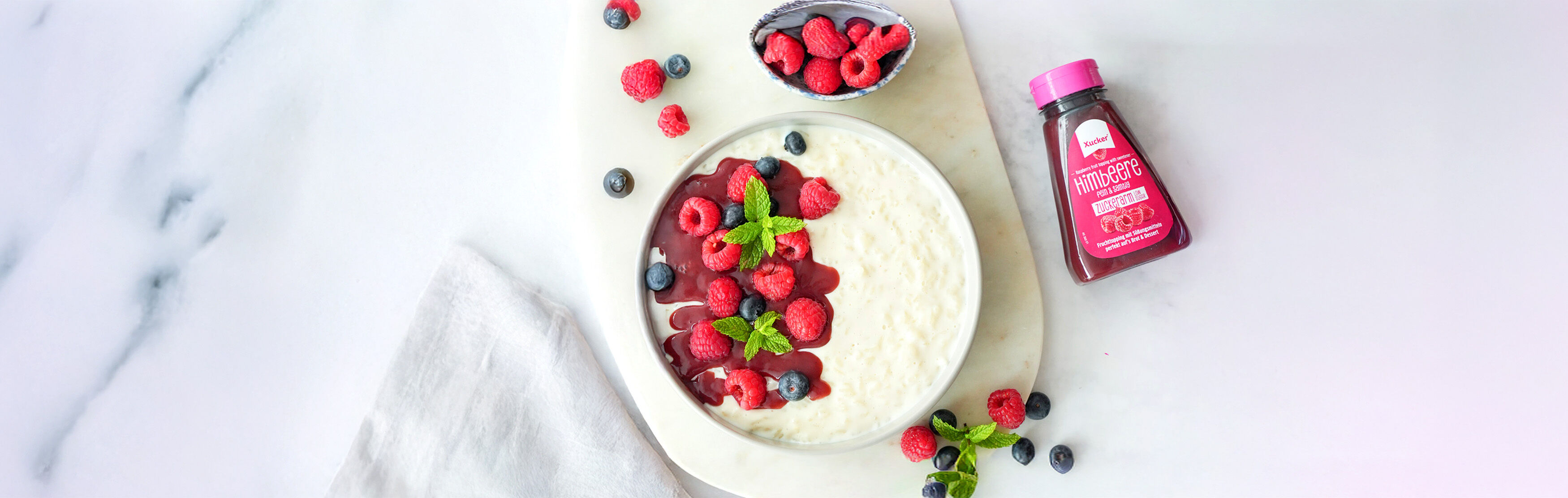 Milchreis mit Beeren angerichtet und Fruchttopping von Xucker ohne zugesetzten Zucker