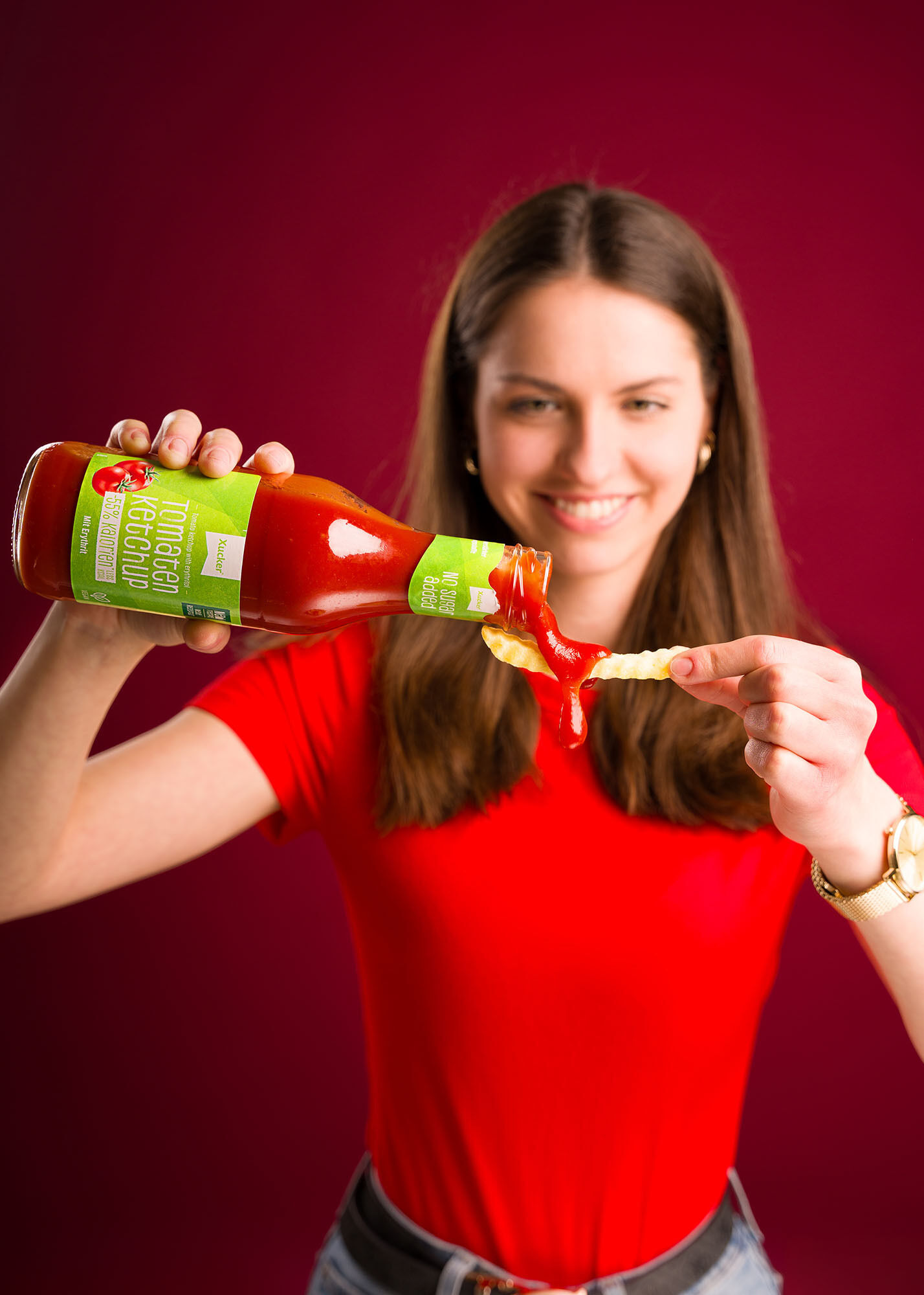 Junge Frau würzt ihr Essen mit Ketchup