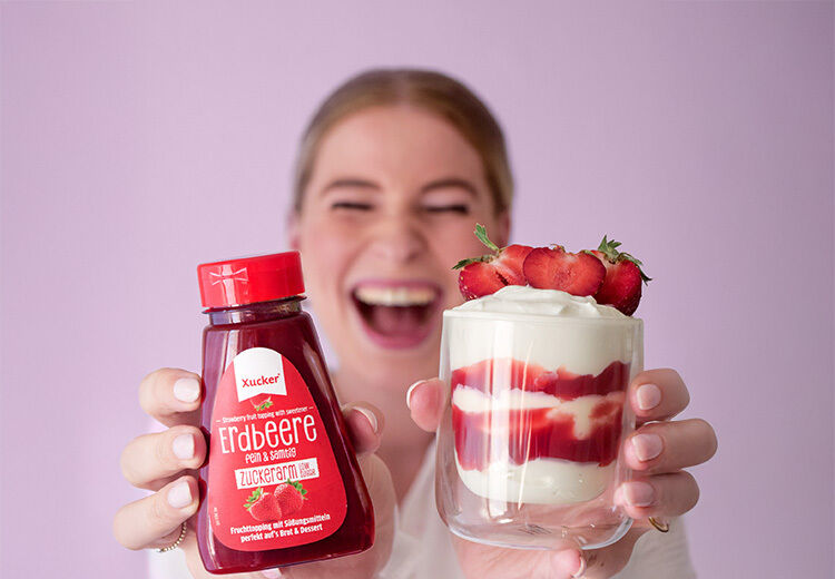 Frau mit Xucker Erdbeer-Fruchttopping und Dessert, zuckerarm, fruchtig und lecker für jede Tageszeit 